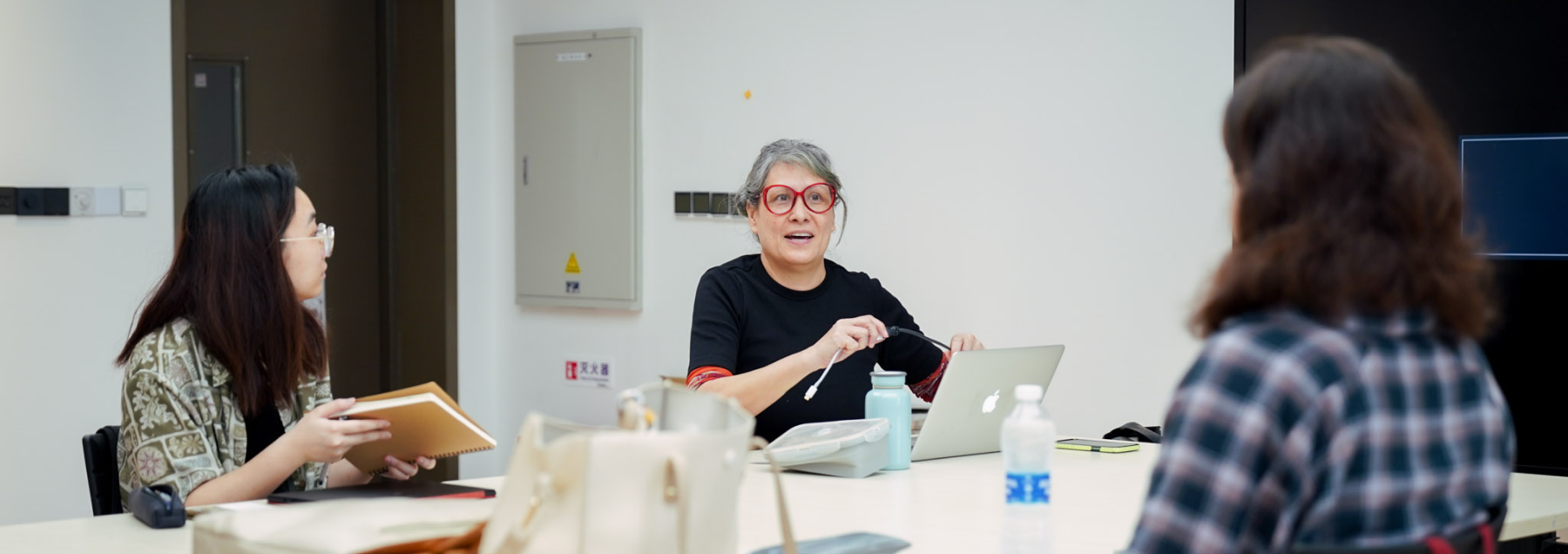 Monika Lin speaking to two students