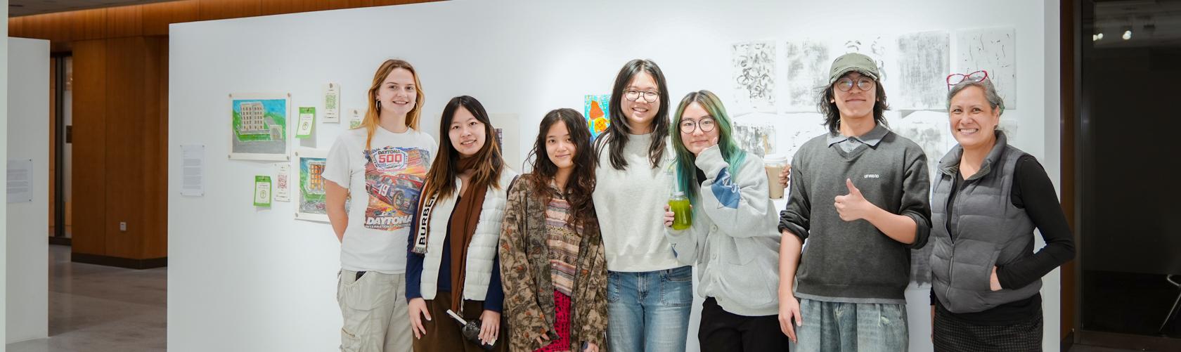group photo between students and faculty infront of student exhibition