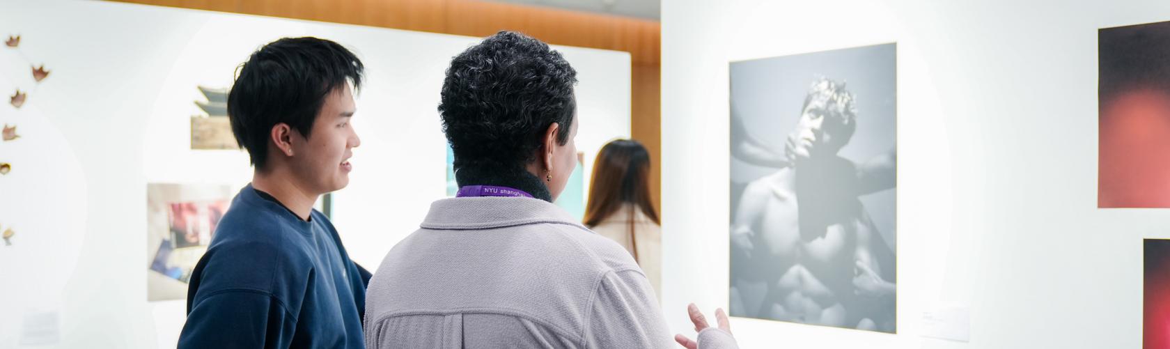 Student and faculty looking at artwork