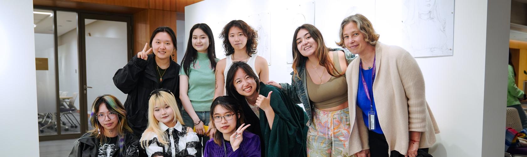 group photo between students and faculty infront of student exhibition