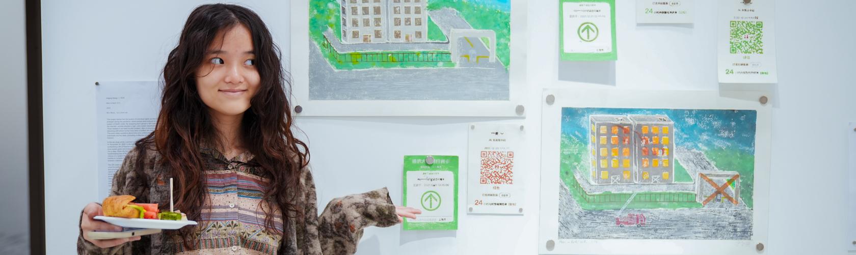 student posing with their artwork